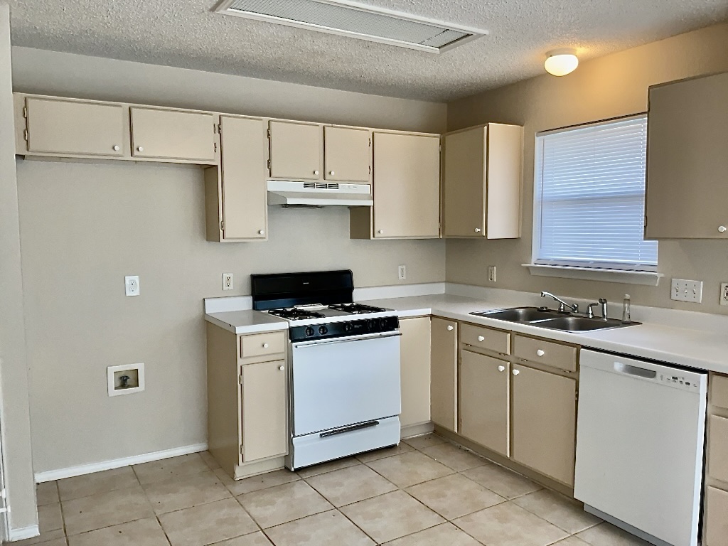 1313 Terra Street Round Rock, TX 78665 - Photo 6 of 25 a kitchen with stainless steel appliances granite countertop a stove a sink and a refrigerator