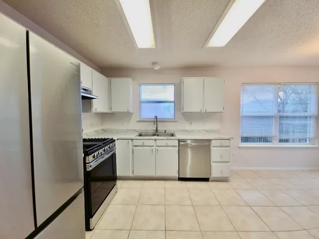 a kitchen with a stove top oven sink and cabinets