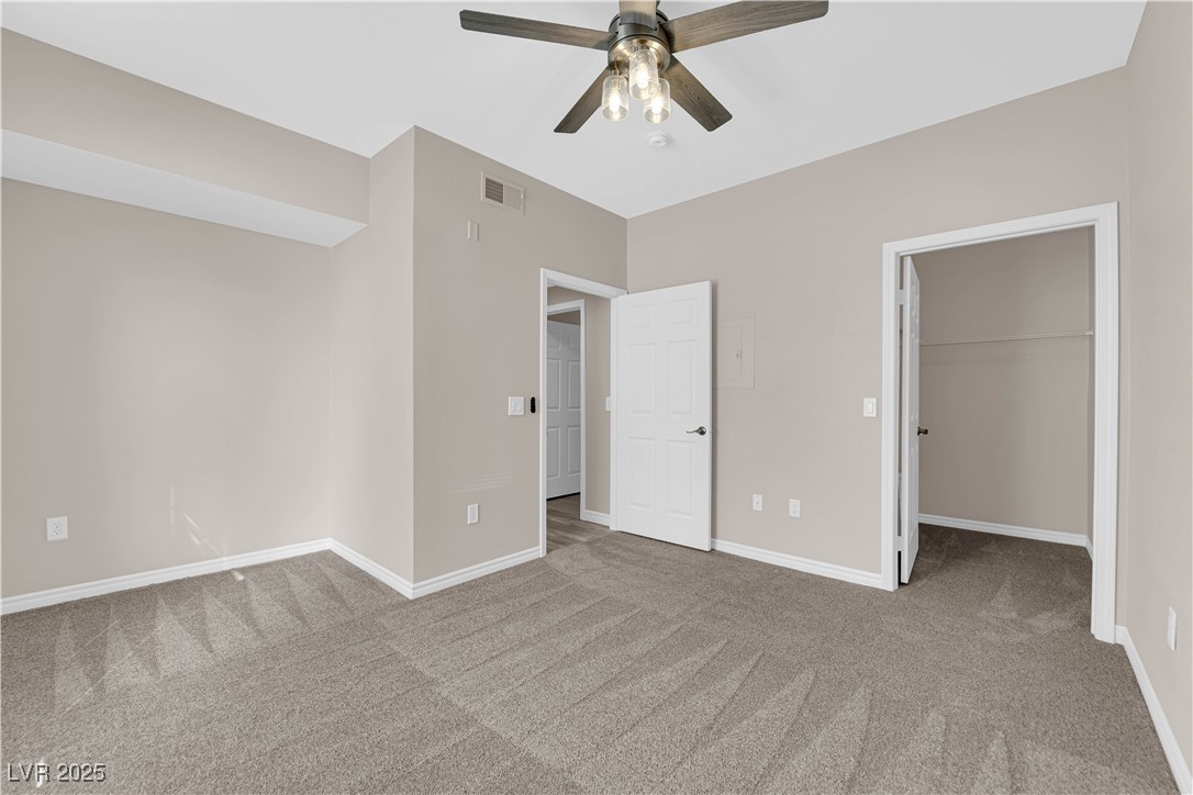 231 West Horizon Ridge Parkway, Unit 1313 Henderson, NV 89012 - Photo 12 of 20 Unfurnished bedroom featuring light colored carpet, a spacious closet, and a ceiling fan