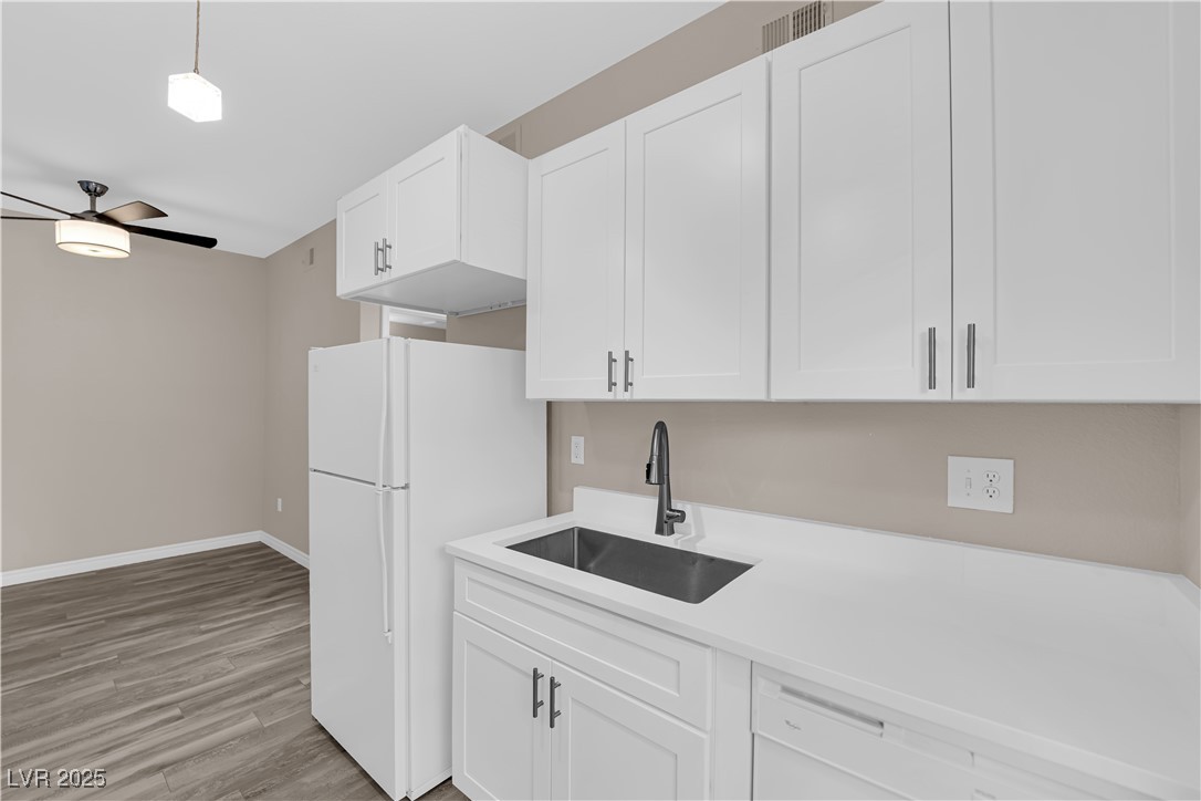 231 West Horizon Ridge Parkway, Unit 1313 Henderson, NV 89012 - Photo 8 of 20 Kitchen with white cabinets, light wood-type flooring, white appliances, hanging light fixtures, and ceiling fan