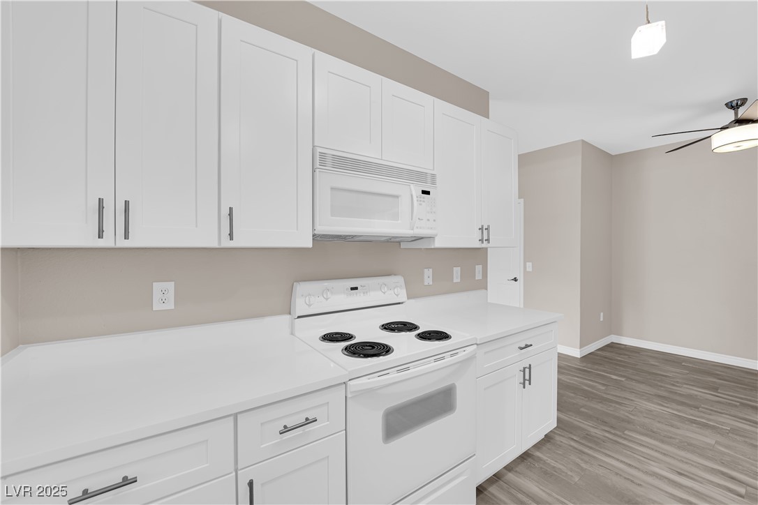 231 West Horizon Ridge Parkway, Unit 1313 Henderson, NV 89012 - Photo 9 of 20 Kitchen with white appliances, white cabinetry, light countertops, and light wood-style floors