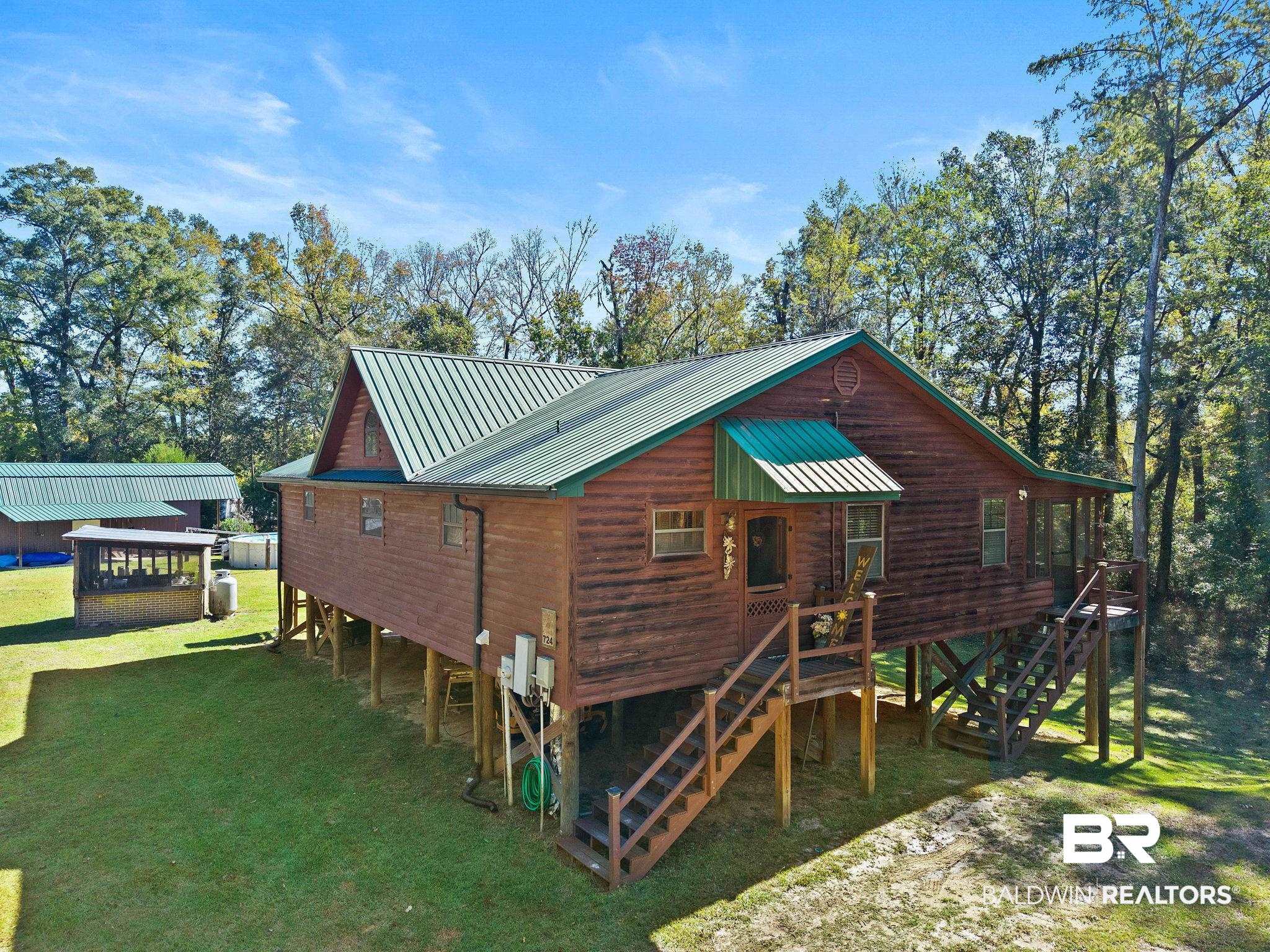 724 Rowell Lane Brewton, AL 36426 - Photo 2 of 40 Rear view of property featuring a yard, a metal roof, stairway, and a wooden deck