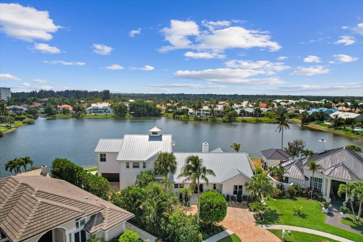 an aerial view of a house with outdoor space and lake view in back
