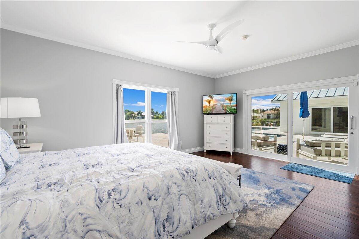 169 Apollo Circle Jupiter, FL 33477 - Photo 22 of 39 a bedroom with a large bed a flat tv screen and dresser