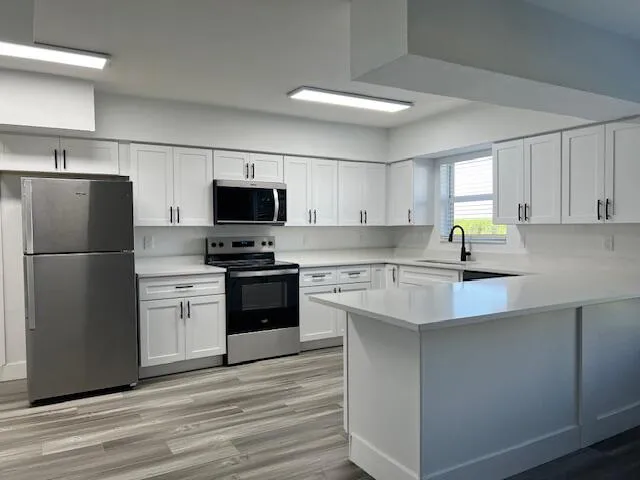 a kitchen with a refrigerator a stove top oven a sink and dishwasher