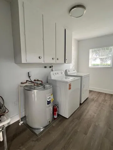 a utility room with wooden floor washer and dryer