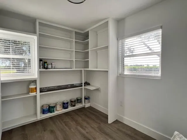 a view of a kitchen with wooden floor and a window