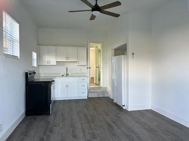 a kitchen with granite countertop a refrigerator and a stove top oven