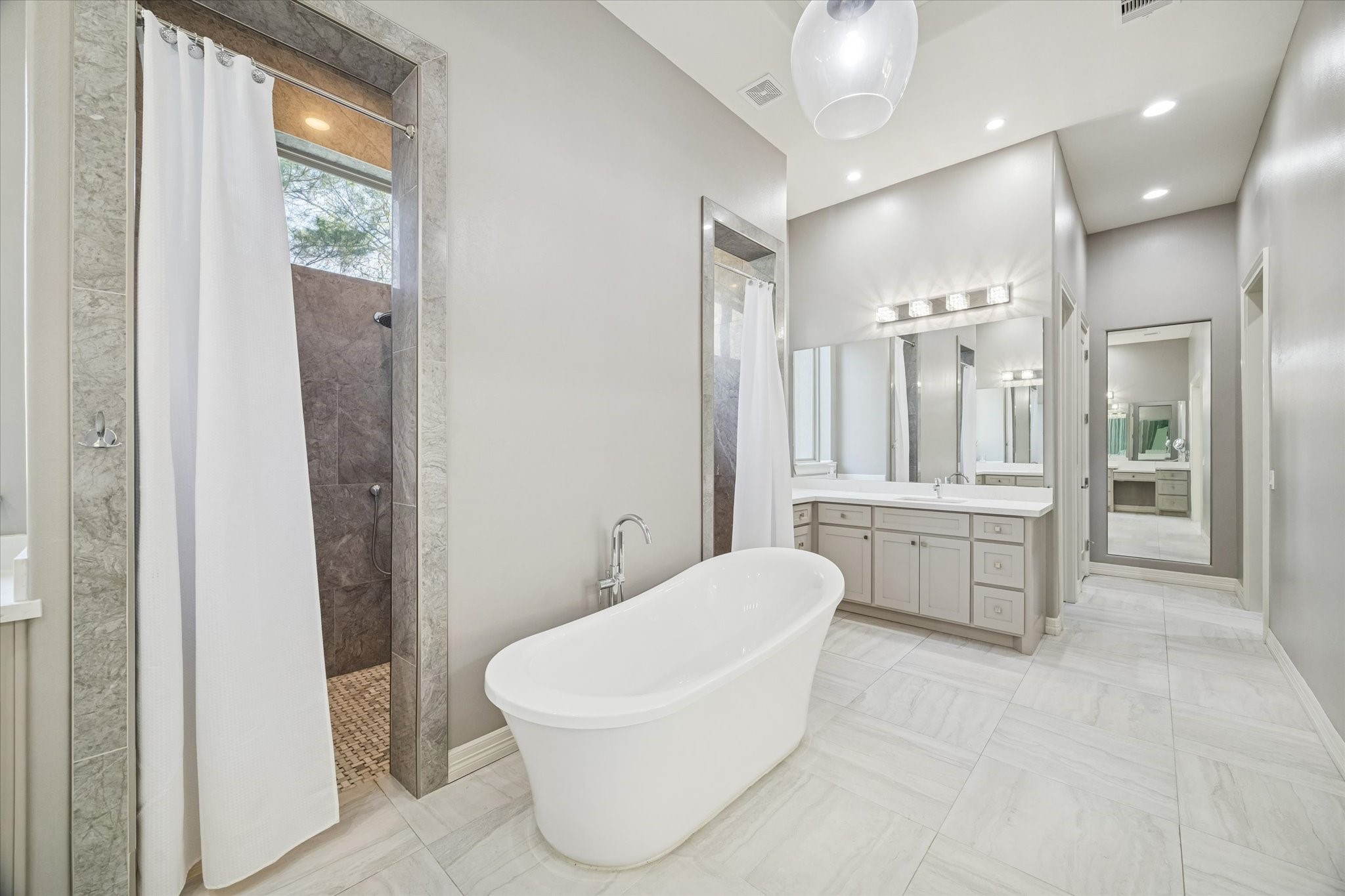 21018 Kings River Point Kingwood, TX 77346 - Photo 30 of 50 a large white bathroom with a large tub shower and sink