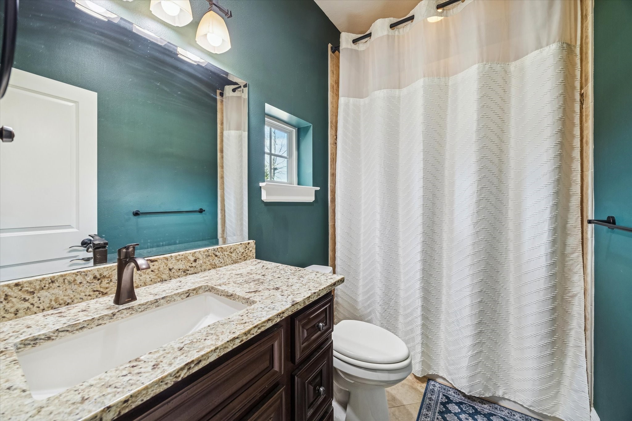 21018 Kings River Point Kingwood, TX 77346 - Photo 40 of 50 a bathroom with a granite countertop sink and a mirror