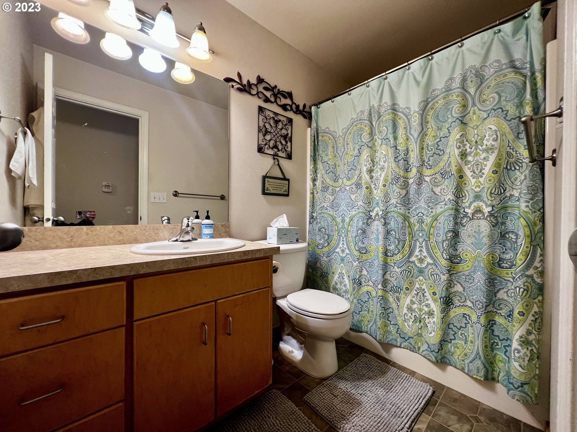 1604 Southwest 2nd Street Pendleton, OR 97801 - Photo 13 of 20 a bathroom with a sink toilet a mirror and shower curtain