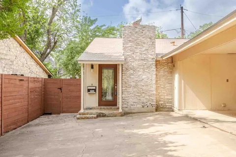 a view of a house with a wooden fence