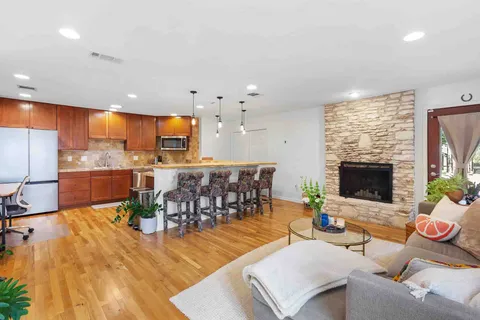 a living room with furniture kitchen view and a large window