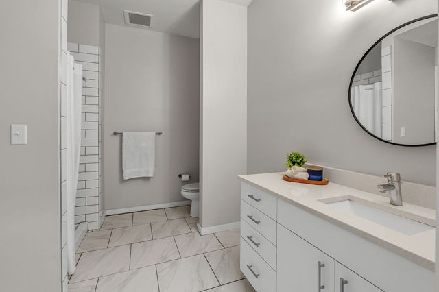 a bathroom with a sink a toilet and a mirror