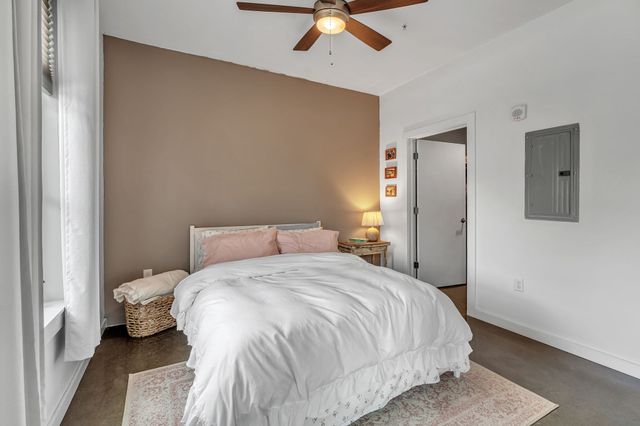 a bedroom with a bed and painting on the wall