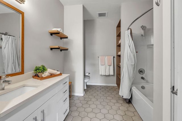 a bathroom with a sink mirror toilet and shower