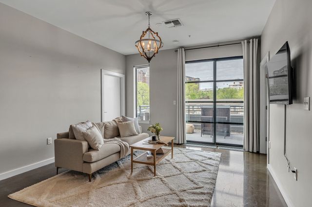 a living room with furniture a flat screen tv and a window