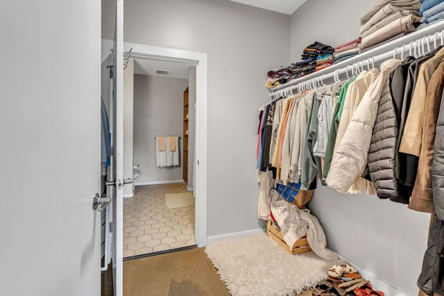 a view of walk in closet with clothes and shoes