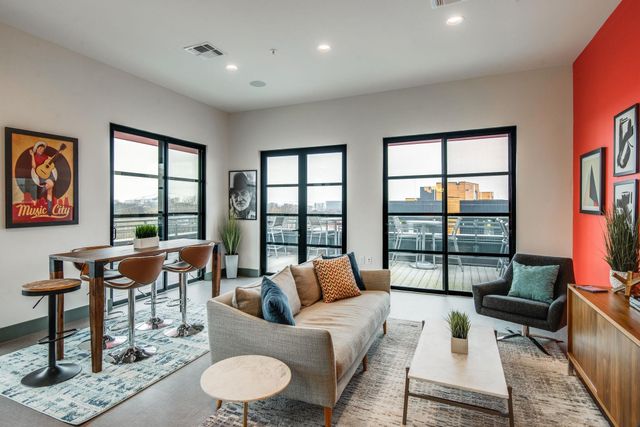 a living room with furniture and a potted plant