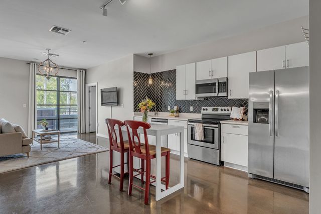 a kitchen with stainless steel appliances granite countertop a stove a sink refrigerator and a microwave