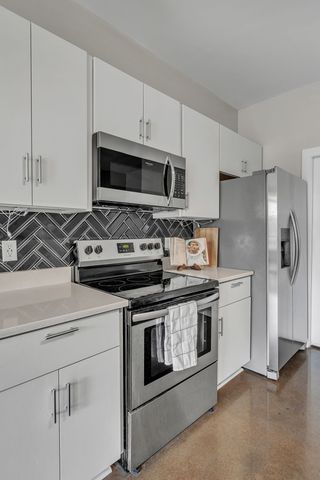 a kitchen with white cabinets and stainless steel appliances