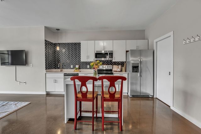 a kitchen with stainless steel appliances a refrigerator and a stove top oven