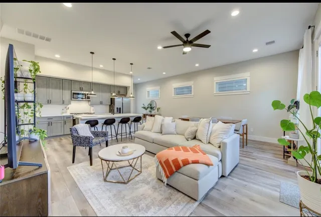 a living room with furniture and a dining table with kitchen view