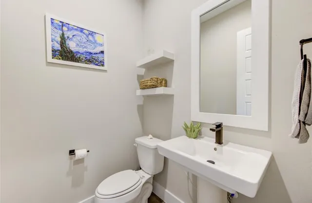 a white toilet sitting next to a bathroom sink