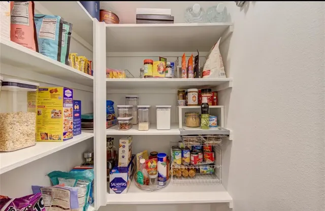 a utility room with fridge and a window