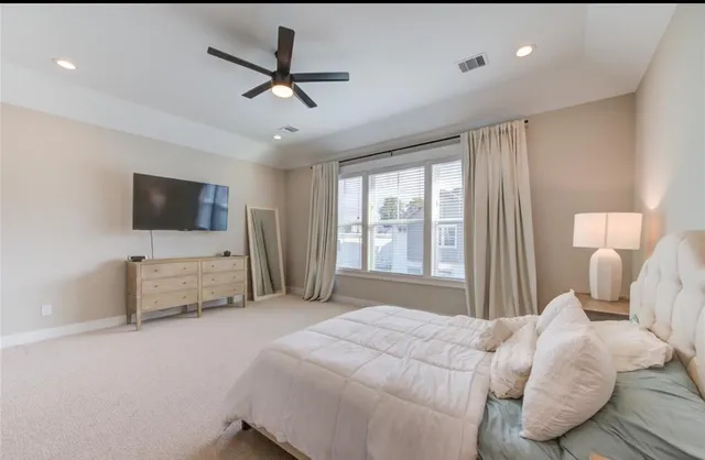 a bedroom with a bed tv and a window