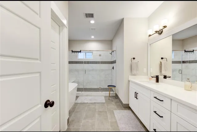 a bathroom with a double vanity sink and mirror with shower