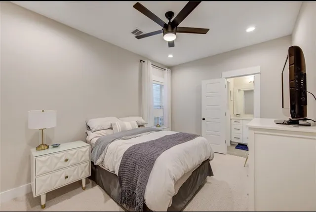 a spacious bedroom with a bed and a chandelier