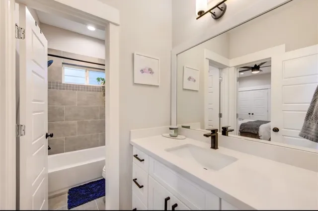a bathroom with a bathtub shower sink and mirror