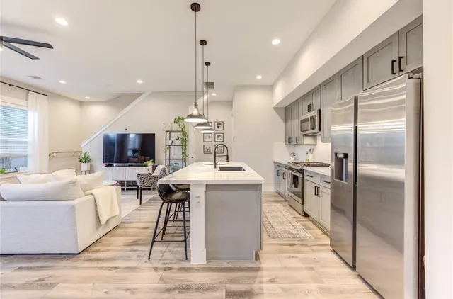 a kitchen with stainless steel appliances granite countertop a sink a stove and a refrigerator