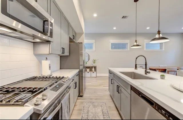 a kitchen with kitchen island a sink stove top oven and cabinets