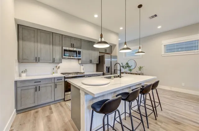 a kitchen with a table chairs sink and cabinets