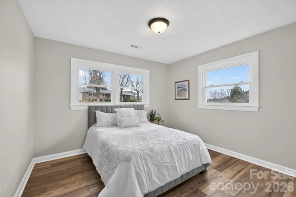 a bedroom with a bed and a painting on the wall