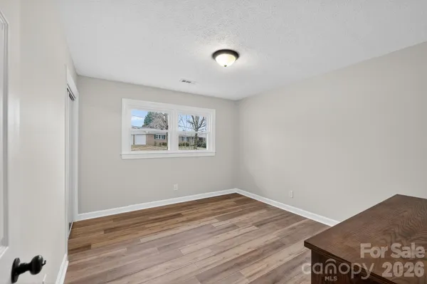a view of a room with wooden floor and white walls