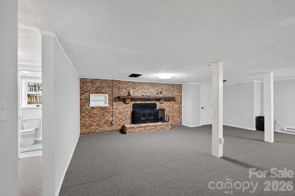 a view of an empty room with a fireplace and a window