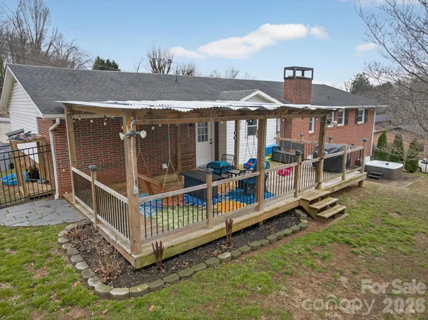 a view of a house with a wooden deck and furniture