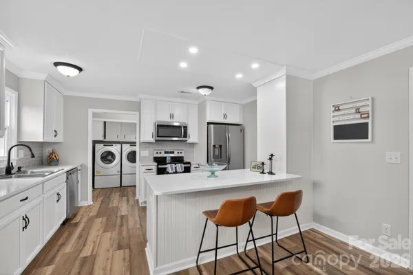 a kitchen with stainless steel appliances kitchen island a sink a stove a refrigerator and cabinets