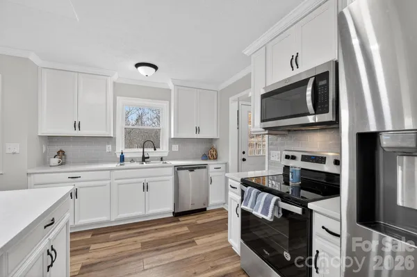 a kitchen with stainless steel appliances a stove microwave and sink