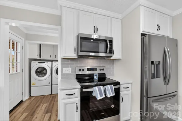 a kitchen with stainless steel appliances granite countertop a refrigerator and a stove top oven
