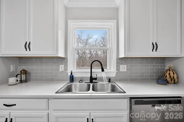 a kitchen with sink a microwave and cabinets