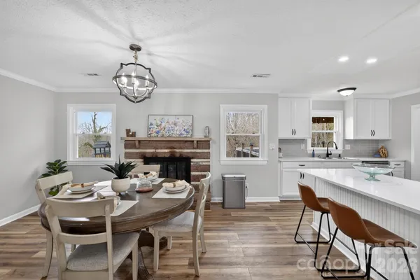 a view of a dining room with furniture a chandelier and wooden floor