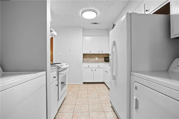 a kitchen with a refrigerator a stove and cabinets