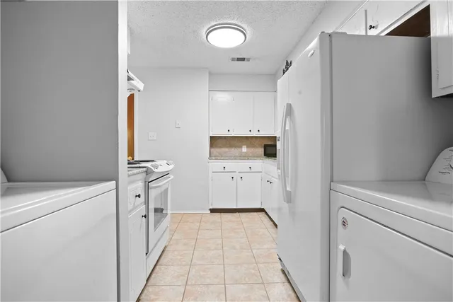 a kitchen with a refrigerator a stove and cabinets