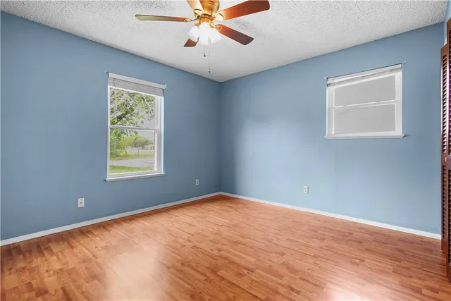 an empty room with a window and a fan