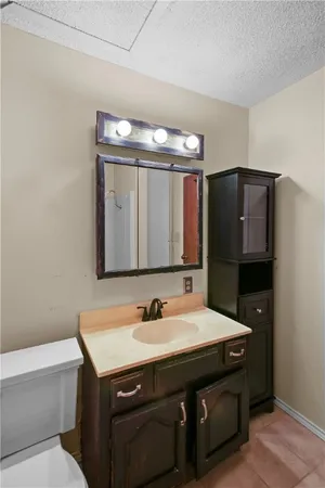 a bathroom with a sink a large mirror and a toilet