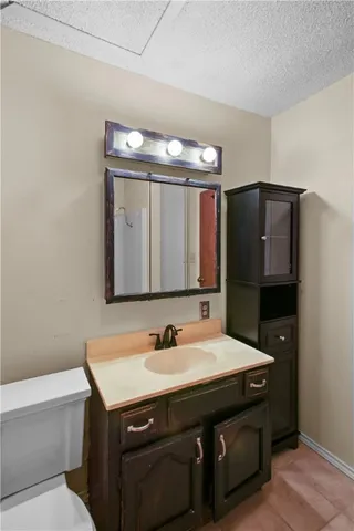 a bathroom with a sink a large mirror and a toilet